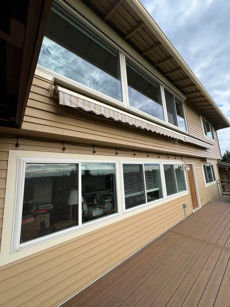 Residential Exterior House Painting with Siding and Trim Beautiful residential house exterior with light brown siding, white trim, and a spacious wooden deck.