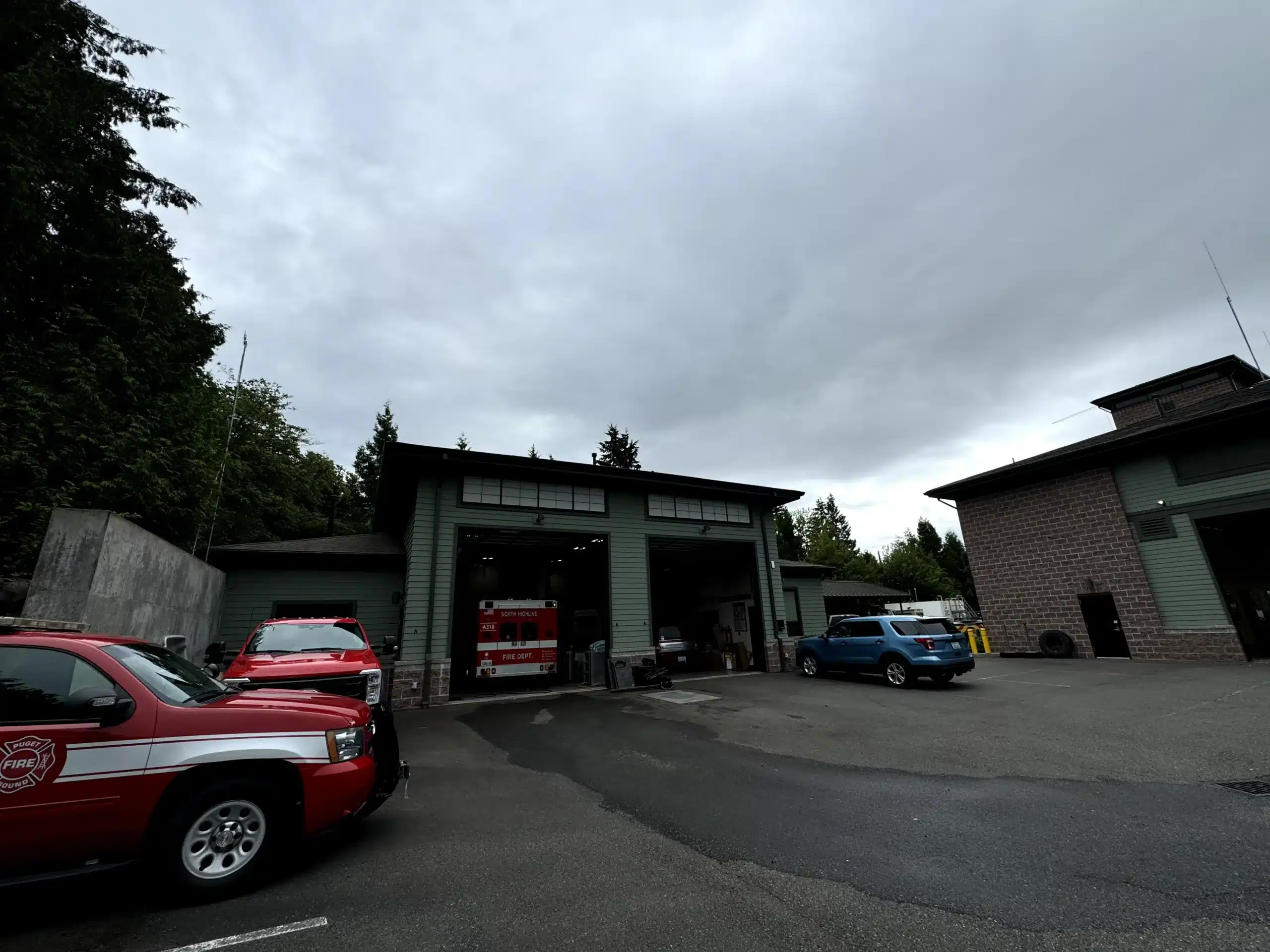 Professional Exterior Painting for Fire Department Facilities Fire station exterior with multiple bays, fire trucks, and red department vehicles, ready for commercial painting.
