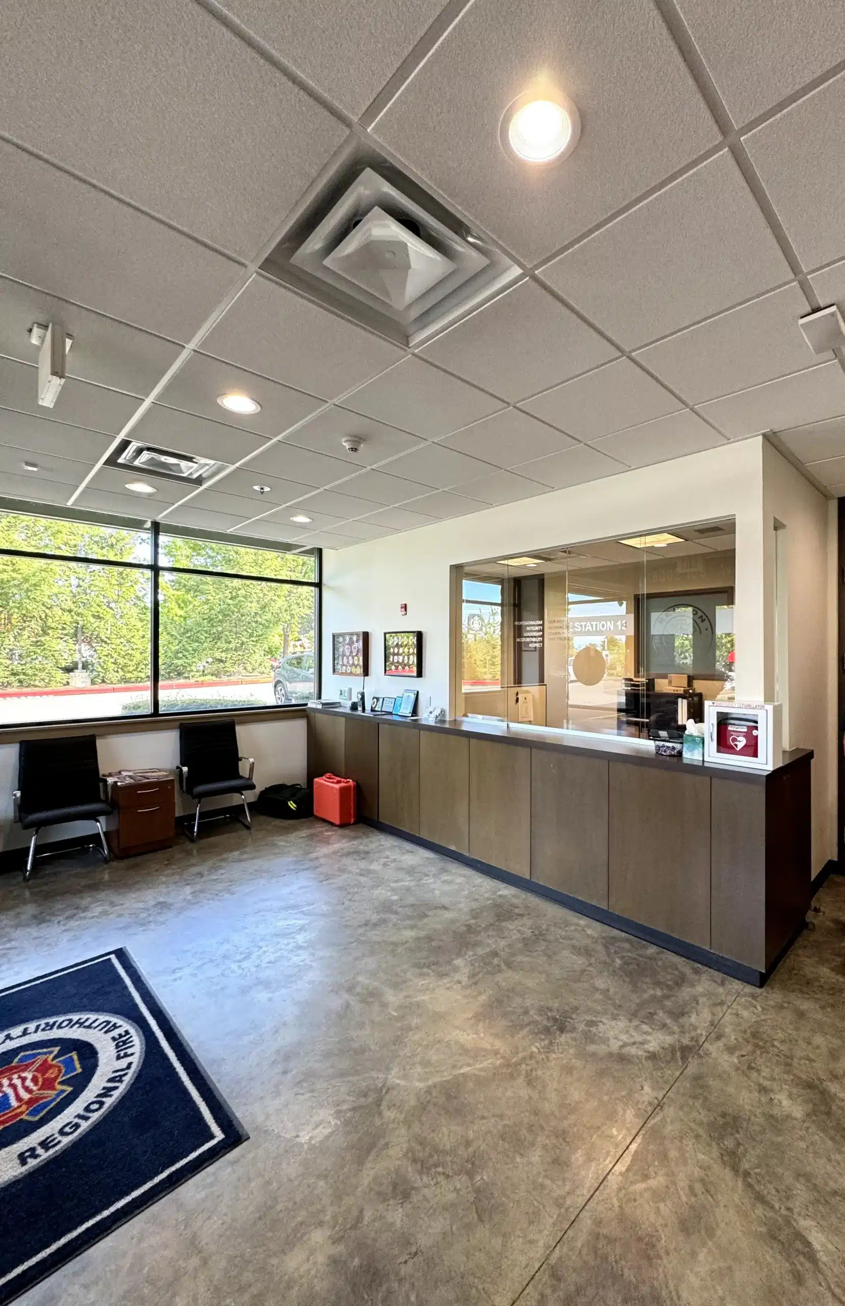Commercial Interior Painting for Office and Reception Areas Bright and clean commercial reception area with a desk, seating, and large windows, perfect for interior painting.