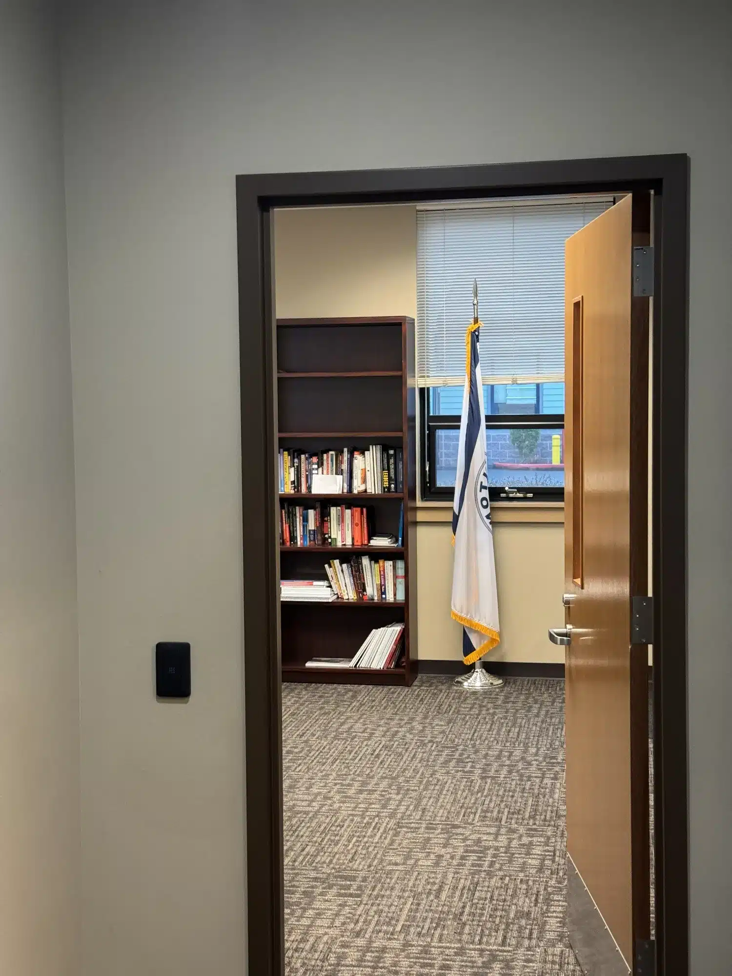 Interior Commercial Office Painting Light gray painted interior commercial office wall with dark-framed glass door and bronze hardware.